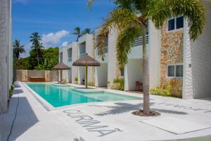 a swimming pool with a palm tree next to a building at Apartamentos Curimã in Passo de Camarajibe