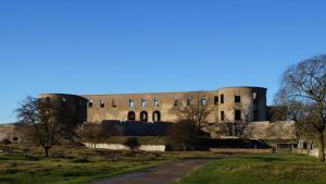 een groot bakstenen gebouw met bomen op de voorgrond bij Villavilla #244 - Öland, Sverige in Grönskog