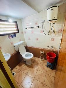 une salle de bain avec des toilettes et un seau dans l'établissement budget stay-mystique inn, à Ooty 11 autres photos