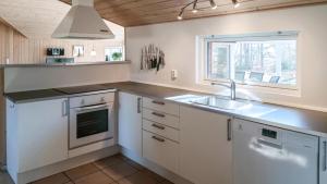 een keuken met witte kasten, een gootsteen en een raam bij Villavilla #244 - Öland, Sverige in Grönskog