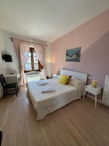 een slaapkamer met een bed, een bureau en een raam bij At Home Bed and Breakfast in Lucca