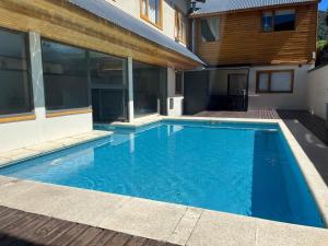 a swimming pool in front of a house at Departamento en pleno centro, con Pileta in San Martín de los Andes