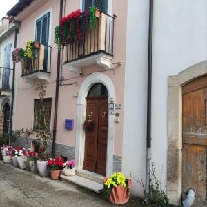 a pink building with a door and flower pots at Bed and Breakfast La Campanula in Vittorito +21 photos