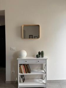 einen weißen Tisch mit einem Spiegel an der Wand in der Unterkunft villa Pieri appartamento black in Fauglia