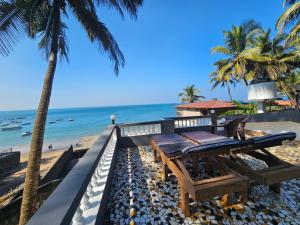 a restaurant on the beach with palm trees and the ocean at Anjuna House With Ocean View in Anjuna