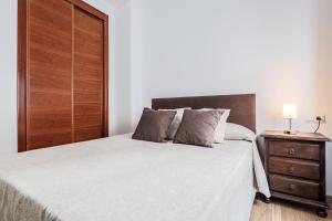 a bedroom with a large bed with a wooden closet at Doctor Fleming in Carmona