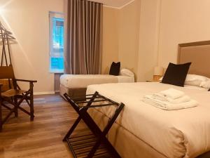 a hotel room with two beds and a chair at Gatto Bianco Carulli in Bari