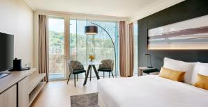a hotel room with a bed and a table with chairs at Lyon Marriott Hotel Cité Internationale in Lyon