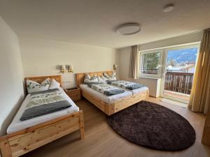 two beds in a room with a window at Appartement Wilhelm in Ehrwald