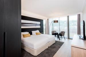 a bedroom with a white bed and a table with chairs at Lyon Marriott Hotel Cité Internationale in Lyon