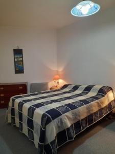 een slaapkamer met een bed met een zwart-witte deken bij Saint jean de monts in Saint-Jean-de-Monts