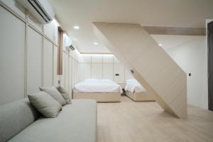 a room with two beds and a couch and a staircase at INSAHAUS Guest House in Kotalama