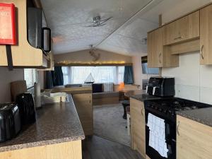 an open kitchen and living room with a couch at Coastal Beachfront Caravan in Brightlingsea
