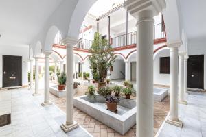 an indoor courtyard with potted plants in a building at Doctor Fleming in Carmona