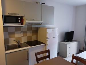 a small kitchen with a sink and a microwave at Chalets de L Isard D N35 2P6 in Les Angles