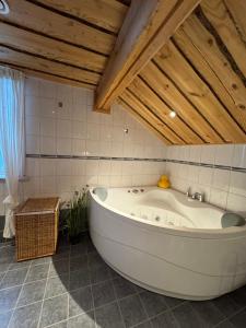 eine große Badewanne in einem Badezimmer mit Holzdecken in der Unterkunft Luxurious Log House - Gränsfors 354 in Bergsjö + 13 Fotos