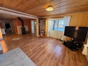 ein Wohnzimmer mit einem großen Flachbildfernseher in der Unterkunft Luxurious Log House - Gränsfors 354 in Bergsjö