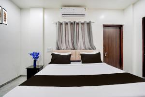 a bedroom with a large white bed and a window at HOTEL O THE COZY INN in Sakardarā