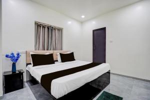 a bedroom with a large bed with black and white sheets at HOTEL O THE COZY INN in Sakardarā