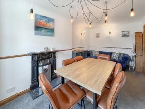 een eetkamer met een houten tafel en stoelen bij Swinton Mill Farm Cottage in Duns