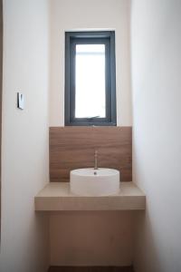 a sink in a bathroom with a window at INSAHAUS Guest House in Kotalama