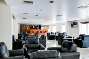 a waiting room with couches and chairs in a building at Hotel Grand Regency, Angamaly in Angamaly