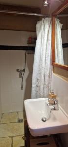 ein Badezimmer mit einem weißen Waschbecken und einem Spiegel in der Unterkunft La Bastide des Muriers in Gargas