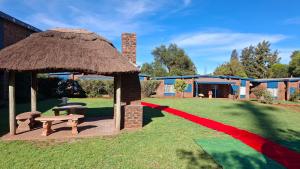 een prieel met een picknicktafel en een bank bij Postmasburg Inn in Postmasburg