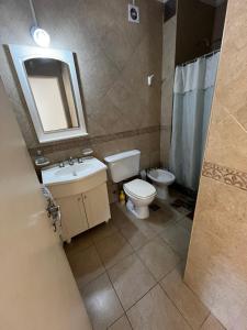 een badkamer met een toilet, een wastafel en een spiegel bij Monoambiente COSTANERA NORTE in Colón