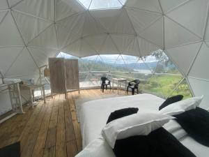 a bedroom in a dome tent with a bed and a table at GLAMPiNG AMOR AMOR GUATAVITA in Guatavita +8 photos