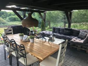een houten tafel en stoelen op een terras bij Czerwony Kominek in Lutek