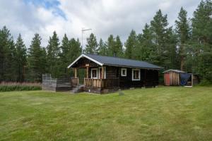 a small cabin in a yard with a grass field at Charmig timmerstuga i Vemdalen in Vemhån