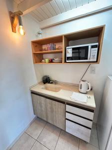 a kitchen with a microwave and a computer on a counter at Loft Costanera in Posadas