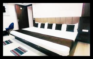 a bedroom with a large bed with a wooden headboard at The Com Fort Inn 