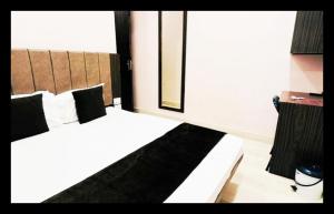a hotel room with two beds with black and white pillows at The Com Fort Inn 