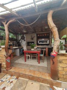 a patio with a red table and a kitchen at Atelie Hospedagem in Palhoça +18 photos