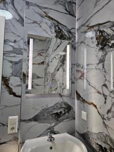 een badkamer met een wastafel en een spiegel bij Hotelikum in Heilbronn +10 foto's