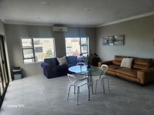 een woonkamer met een tafel en een bank bij Pado B & B in Gqeberha