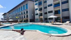 een groot zwembad voor een gebouw bij Max Carneiros Suítes - Com e sem piscina privativa in Praia dos Carneiros