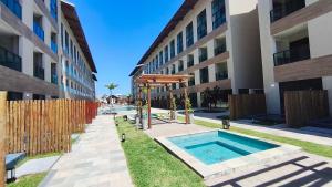 een zwembad op een binnenplaats tussen twee gebouwen bij Max Carneiros Suítes - Com e sem piscina privativa in Praia dos Carneiros