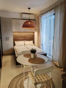 een slaapkamer met een bed en een tafel en stoelen bij SOHO apartments in Boergas +4 foto's