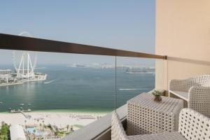 a balcony with chairs and a view of the ocean at JA Ocean View Hotel, Jumeirah Beach Dubai in Dubai