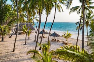 a beach with palm trees and the ocean at Diamonds Malindi in Malindi