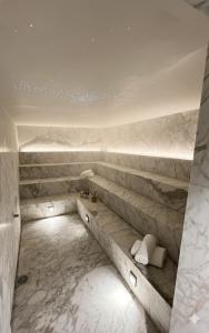 a bathroom with white marble walls and a bench at Yoo Punta del este Deluxe in Punta del Este