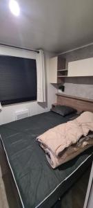 ein großes Bett in einem Zimmer mit Fenster in der Unterkunft Melfloto in Parentis-en-Born