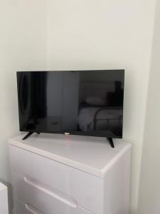 Elle comprend une télévision à écran plat installée au-dessus d'une commode blanche. dans l'établissement Chic & Cosy Studio Apartment, à Southampton 12 autres photos