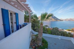 a house with a palm tree and a view of the water at CALLIOPE MAILLE studios & apartments in Myrties