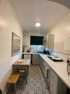 une petite cuisine avec une table et une petite table dans l'établissement Chic & Cosy Studio Apartment, à Southampton