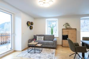 a living room with a couch and a table at Murleben Appartements - Nahe Red Bull Ring & Kreischberg in Stadl an der Mur