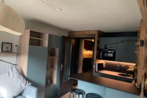 a room with a kitchen with a sink and a counter at Charming studio with terrace and garden in Praz-sur-Arly